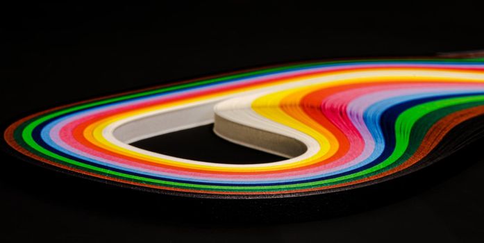 Abstract color wave curl rainbow strip paper on black background