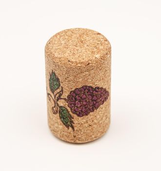 an isolatd cork with little painting of grape on it
