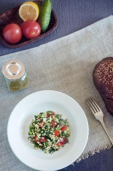 Light and tasty salad of middle Eastern cuisine Tabule , prepared from vegetables, herbs , bulgur cereals, seasoned with lemon juice and olive oil.