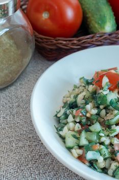 Light and tasty salad of middle Eastern cuisine Tabule , prepared from vegetables, herbs , bulgur cereals, seasoned with lemon juice and olive oil.