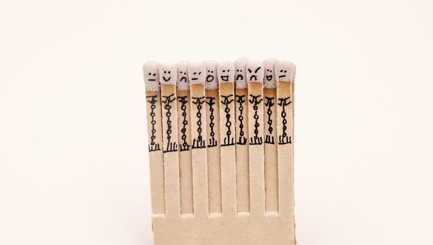 matchsticks with faces painted on the heads on white on white