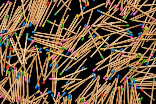 multicolored match sticks on a black background