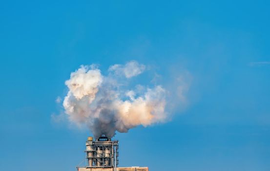 Smoke from the factory chimney. Air emissions polluting the city.