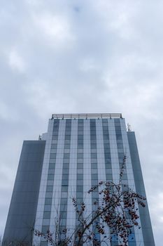 the blue glass building on cloudy sky