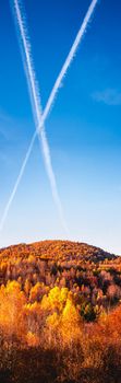 the hill in autumn with an x in the sky from planes