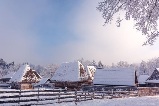 Traditional Romanian village with old house straw roofing covered with snow