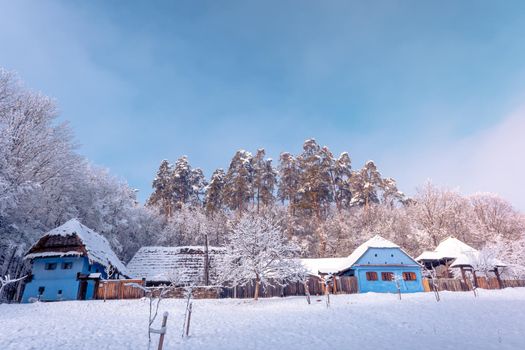 Traditional Romanian village in Transylvania with old house straw roofing covered with snow in a cold day