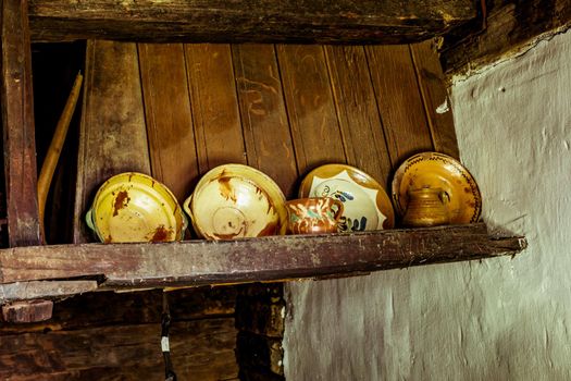 Transylvanian traditional old interior house in the countryside with clay soil floor and table with clay pots