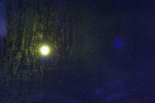 Water drops reflections on the window in night