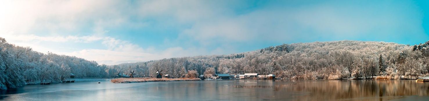 Winter panorama with windmills on a foggy winter day