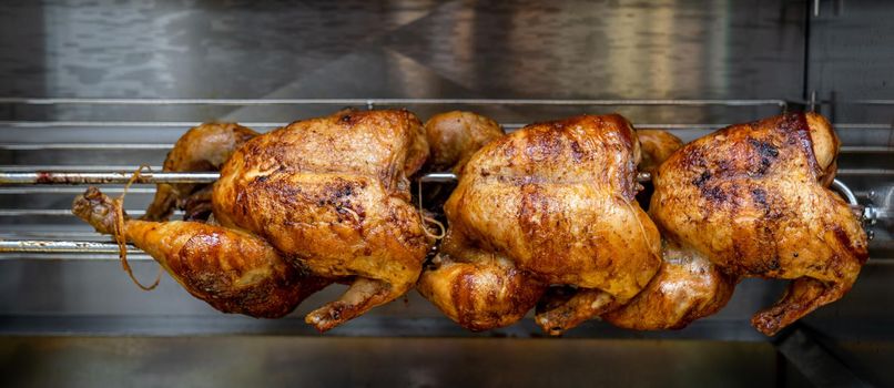 roasted chicken on a stick on the grill.