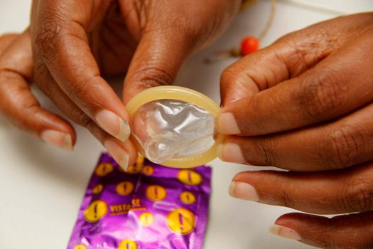 salvador, bahia / brazil - february 6, 2013: hand holds male condom, contraceptive method and also used to control sexually transmitted diseases.
