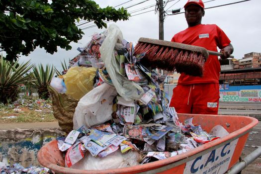 salvador, bahia / brazil - october 8, 2012: Gari is seen collecting electoral propaganda pamphlet paper during elections in the city of Salvador.
