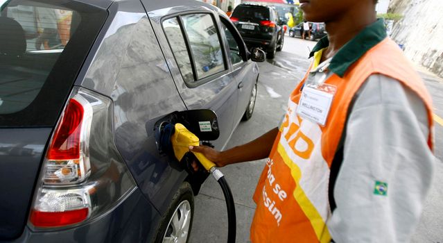 salvador, bahia / brazil - october 8, 2014: gas station attendant is seen filling up a vehicle at petrol stations in the Petrobras network, in the city of Salvador.