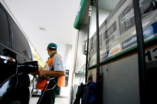 salvador, bahia / brazil - october 8, 2014: gas station attendant is seen filling up a vehicle at petrol stations in the Petrobras network, in the city of Salvador.