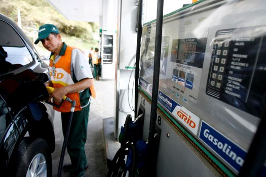 salvador, bahia / brazil - october 8, 2014: gas station attendant is seen filling up a vehicle at petrol stations in the Petrobras network, in the city of Salvador.