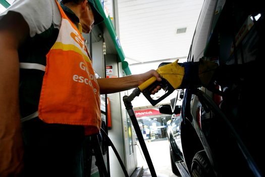 salvador, bahia / brazil - october 8, 2014: gas station attendant is seen filling up a vehicle at petrol stations in the Petrobras network, in the city of Salvador.