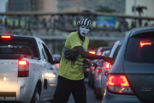 salvador, bahia / brazil -  november 8, 2017: Man takes advantage of the closed traffic light for drivers and faces traffic to sell bullets in the city of Salvador. 