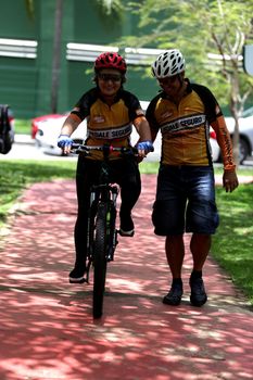 salvador, bahia / brazil - november 8, 2018: instructor helps a person to use a bicycle in the city of Salvador.