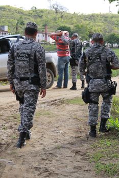 pau brasil, bahia / brazil - may 10, 2012: National Force military personnel approach vehicles and people traveling in rural Pau Brasil after armed conflict between Pataxo Hahahae ethinics and farmers .