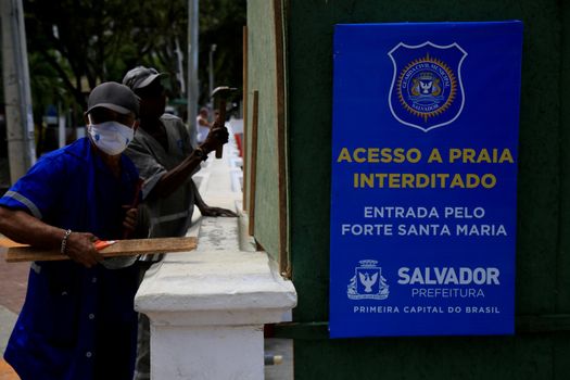 salvador, bahia, brazil - december 14, 2020: city hall worker interdicts Porto da Barra beach in the city of Salvador, due to the Covid-19 invention.