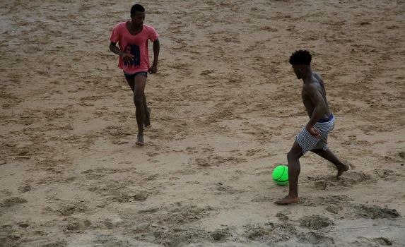 salvador, bahia, brazil - january 15, 2021: people are seen playing football on Ondina beach in the city of Salvador.