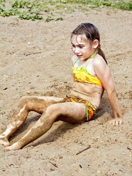 Girl sitting on sand by the river