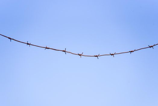 barbed wire against a blue sky background.