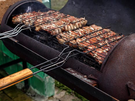 Meat for shish kebab is fried on grill.