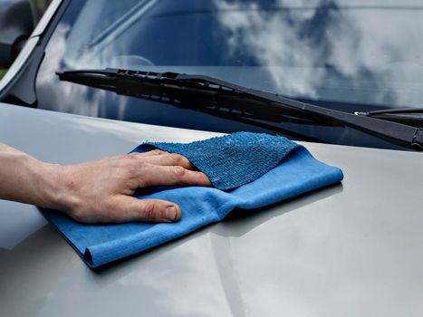 Car detailing and cleaning by hand and microfiber towel. Polishing the car exterior with car shine products or wax result in shine surface.