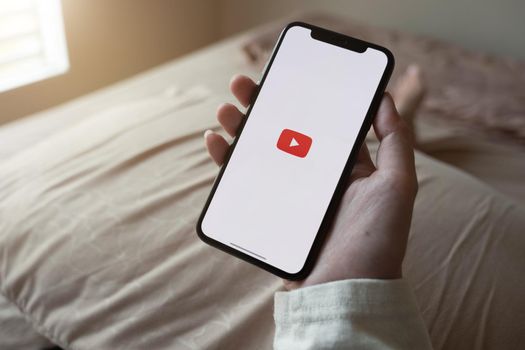 CHIANG MAI, THAILAND - JUNE 7, 2020: Latest generation iPhone X with YouTube logo on the screen.