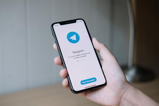 CHIANG MAI, THAILAND, JUN 22, 2020 : Woman hand holding iPhone X with social networking service Telegram on the screen. iPhone 10 was created and developed by the Apple inc.