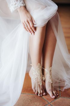 Bride in white wedding dress opened bare feet. High quality photo