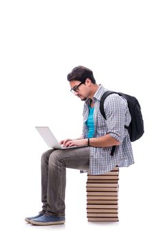 Young student sitting on top of book stack on white