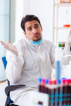 Young chemist student working in lab on chemicals