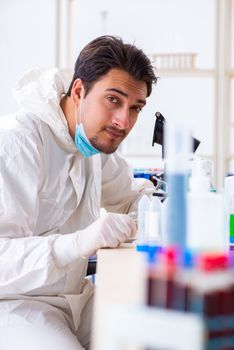 Young chemist student working in lab on chemicals