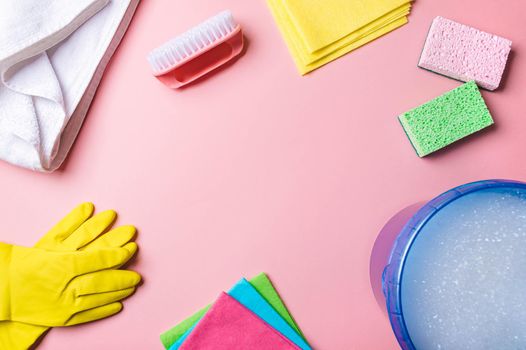 House cleaning product and bucket, pail, container with foam on pink background, copy space. Flat lay or top view. Cleaning service or housekeeping concept with space for text or design ic center