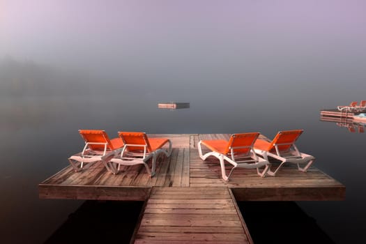 view of a boat dock the Lac-Superieur, misty morning with fog, in Laurentides, Mont-tremblant, Quebec, Canada