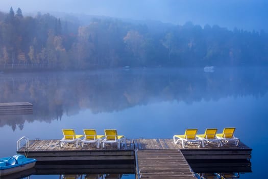 view of a boat dock the Lac-Superieur, misty morning with fog, in Laurentides, Mont-tremblant, Quebec, Canada