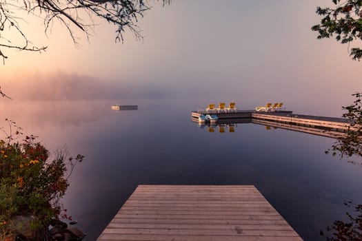 view of a boat dock the Lac-Superieur, misty morning with fog, in Laurentides, Mont-tremblant, Quebec, Canada