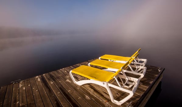 view of a boat dock the Lac-Superieur, misty morning with fog, in Laurentides, Mont-tremblant, Quebec, Canada