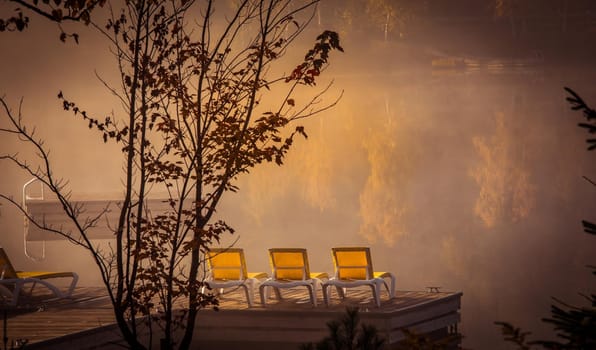 view of a boat dock the Lac-Superieur, misty morning with fog, in Laurentides, Mont-tremblant, Quebec, Canada