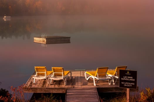 view of a boat dock the Lac-Superieur, misty morning with fog, in Laurentides, Mont-tremblant, Quebec, Canada