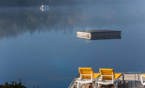 view of a boat dock the Lac-Superieur, misty morning with fog, in Laurentides, Mont-tremblant, Quebec, Canada