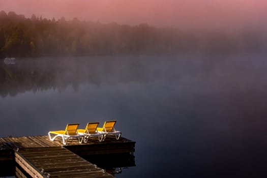 view of a boat dock the Lac-Superieur, misty morning with fog, in Laurentides, Mont-tremblant, Quebec, Canada