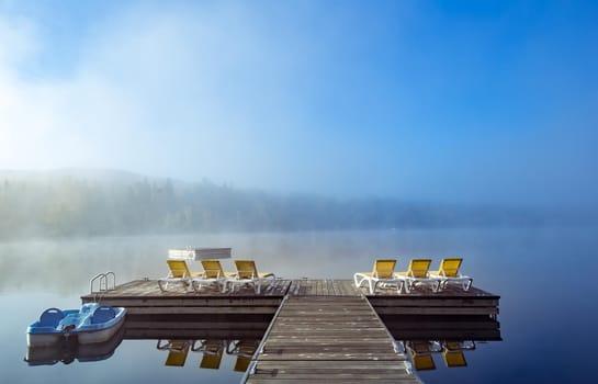 view of a boat dock the Lac-Superieur, misty morning with fog, in Laurentides, Mont-tremblant, Quebec, Canada