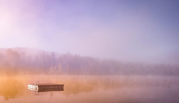 view of a boat dock the Lac-Superieur, misty morning with fog, in Laurentides, Mont-tremblant, Quebec, Canada