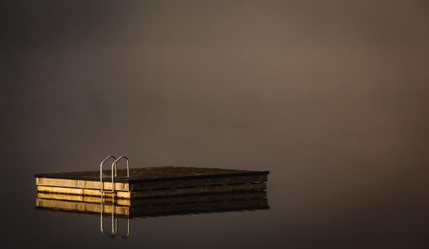 view of a boat dock the Lac-Superieur, misty morning with fog, in Laurentides, Mont-tremblant, Quebec, Canada