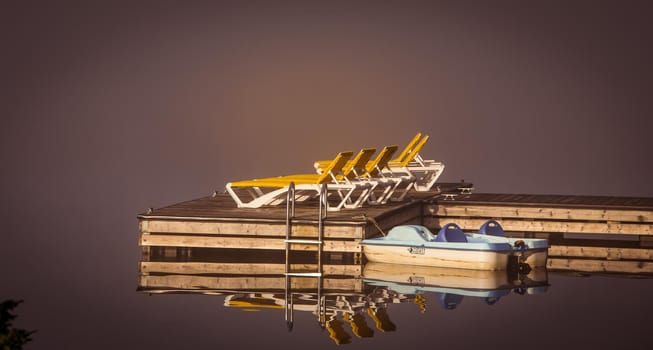 view of a boat dock the Lac-Superieur, misty morning with fog, in Laurentides, Mont-tremblant, Quebec, Canada