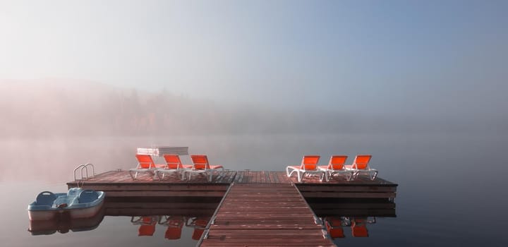 view of a boat dock the Lac-Superieur, misty morning with fog, in Laurentides, Mont-tremblant, Quebec, Canada